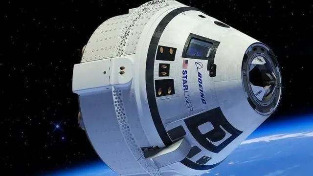 Starliner kapsülü uzayda. Dünya'nın çeperi fotoğrafın alt kısmında mavi bir ışık huzmesi şeklinde görülebiliyor.
